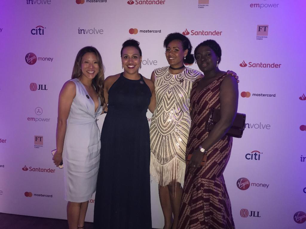 Four women of colour posing and smiling